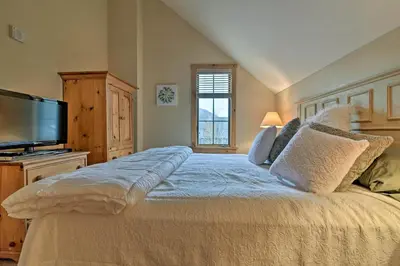 a bedroom with a large bed and a flat screen tv at Keystone Ski Condo with Mtn View - Walk to Gondola! in Keystone