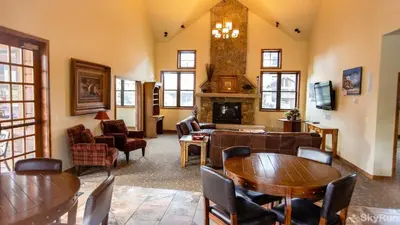 a living room with tables and chairs and a fireplace at Trailhead Lodge One Bedroom 801 condo in Winter Park