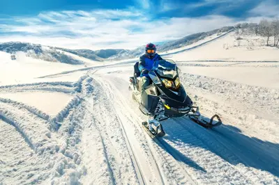 a person riding a snow bike in the snow at Trailhead Lodge One Bedroom 801 condo in Winter Park
