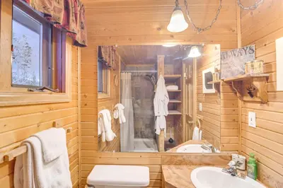 a log cabin bathroom with a sink and a shower at 2 Mi to Rocky Mountain Natl Park Cabin with Views in Grand Lake