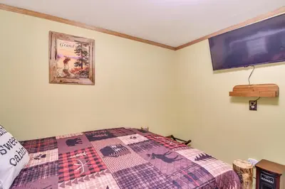 a bedroom with a bed and a tv on the wall at 2 Mi to Rocky Mountain Natl Park Cabin with Views in Grand Lake