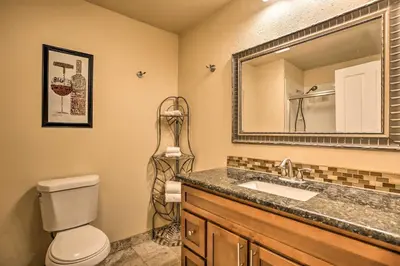 a bathroom with a toilet and a sink and a mirror at Greenwood Village Condo with Pool Access! in Greenwood Village