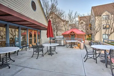 a patio with tables and chairs and a grill at Greenwood Village Condo with Pool Access! in Greenwood Village