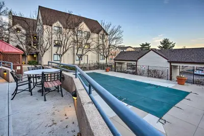 a tennis court in a backyard with a table at Greenwood Village Condo with Pool Access! in Greenwood Village