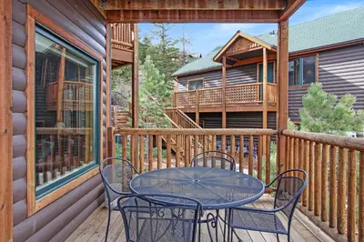 a table and chairs on the deck of a cabin at Deer Mountain 28B condo in Estes Park
