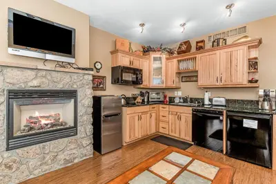 a kitchen with a fireplace and a tv on the wall at Deer Mountain 28B condo in Estes Park