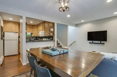 a kitchen and living room with a large wooden table at Updated Townhome Near Main Street, 10 Mi to Breck! in Frisco