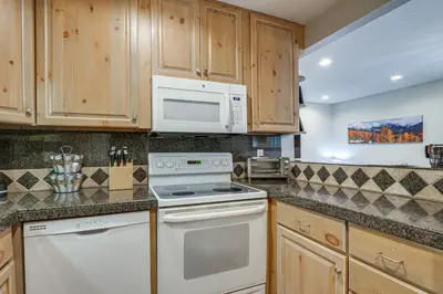 a kitchen with white appliances and wooden cabinets at Updated Townhome Near Main Street, 10 Mi to Breck! in Frisco
