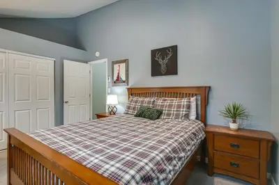 a bedroom with a bed with a plaid bedspread at Updated Townhome Near Main Street, 10 Mi to Breck! in Frisco