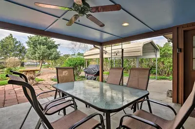 a table and chairs on a patio with a ceiling fan at Arvada Home with Beautifully Landscaped Yard! in Arvada
