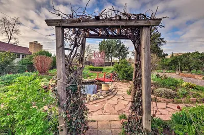 a wooden arch in a garden with a pathway at Arvada Home with Beautifully Landscaped Yard! in Arvada