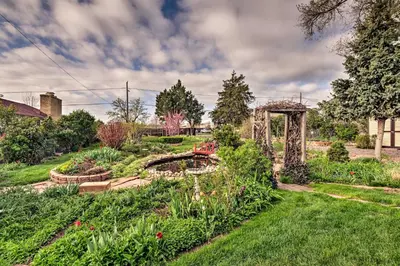 a garden with a bridge and flowers in a yard at Arvada Home with Beautifully Landscaped Yard! in Arvada