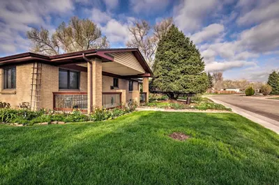 a house with a tree in front of a yard at Arvada Home with Beautifully Landscaped Yard! in Arvada
