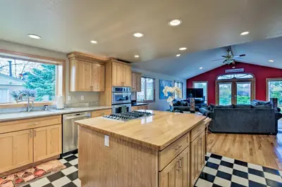 a kitchen with wooden cabinets and a stove top island at Arvada Home with Beautifully Landscaped Yard! in Arvada
