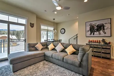a living room with a couch and a large window at Modern Winter Park Ski Condo Near the Ski Shuttle! in Winter Park