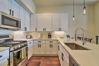 a kitchen with white cabinets and a sink at Modern Winter Park Ski Condo Near the Ski Shuttle! in Winter Park