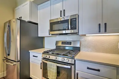 a kitchen with a stove and a microwave at Modern Winter Park Ski Condo Near the Ski Shuttle! in Winter Park