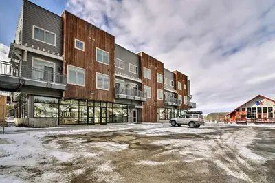 a car parked in a parking lot in front of a building at Modern Winter Park Ski Condo Near the Ski Shuttle! in Winter Park