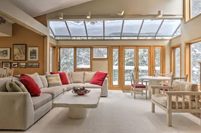 a living room with a couch and a window at Ski-InandSki-Out Winter Park Condo with Pool Access! in Winter Park