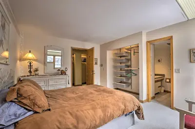 a bedroom with a large bed and a sink at Ski-InandSki-Out Winter Park Condo with Pool Access! in Winter Park