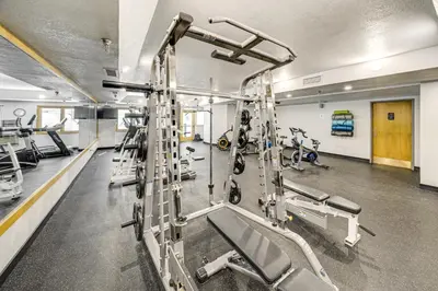 a gym with several treadmills and machines at Ski-InandSki-Out Winter Park Condo with Pool Access! in Winter Park