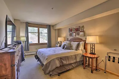a bedroom with a bed and a tv and a window at Cozy Ski-InandSki-Out Winter Park Resort Condo! in Winter Park