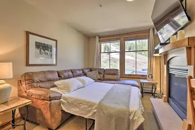 a living room with a couch and a fireplace at Cozy Ski-InandSki-Out Winter Park Resort Condo! in Winter Park