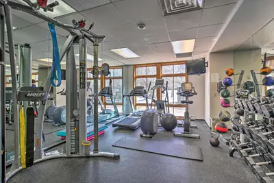 a gym with several tread machines and weights at Cozy Ski-InandSki-Out Winter Park Resort Condo! in Winter Park