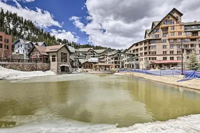 a town in the snow with a river at Cozy Ski-InandSki-Out Winter Park Resort Condo! in Winter Park