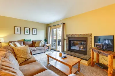 a living room with a couch and a fireplace at Cozy Winter Park Condo with Hot Tub and Shuttle! in Winter Park
