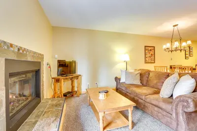 a living room with a couch and a fireplace at Cozy Winter Park Condo with Hot Tub and Shuttle! in Winter Park