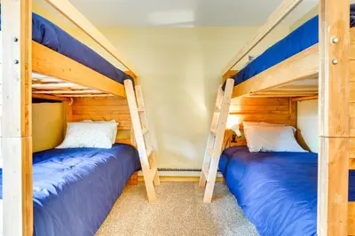 two bunk beds in a room with blue beds at Cozy Winter Park Condo with Hot Tub and Shuttle! in Winter Park