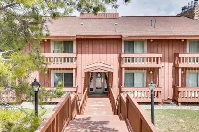 a wooden building with a wooden bridge in front of it at Cozy Winter Park Condo with Hot Tub and Shuttle! in Winter Park