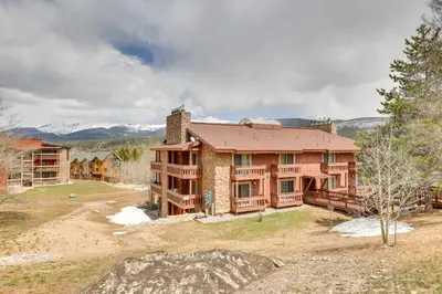 an exterior view of a house with mountains in the background at Cozy Winter Park Condo with Hot Tub and Shuttle! in Winter Park