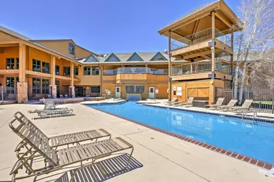 a resort with a swimming pool and lounge chairs at Granby Condo with Pool Access, Near Hiking and Skiing! in Granby