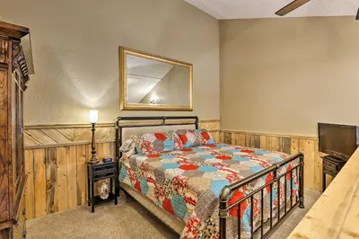 a bedroom with a bed and a television at Granby Condo with Pool Access, Near Hiking and Skiing! in Granby