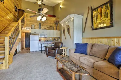 a living room with a couch and a kitchen at Granby Condo with Pool Access, Near Hiking and Skiing! in Granby