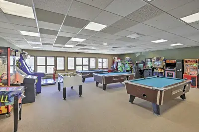 a play room with pool tables and arcade machines at Granby Condo with Pool Access, Near Hiking and Skiing! in Granby