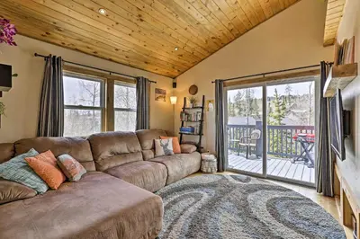 a living room with a couch and a sliding glass door at 10 Mi to Ski Condo with Mtn Views in Silverthorne in Silverthorne