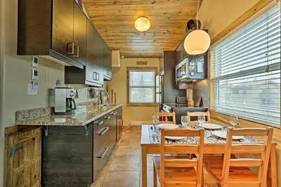 a kitchen with a table and chairs and a kitchen with a counter at 10 Mi to Ski Condo with Mtn Views in Silverthorne in Silverthorne