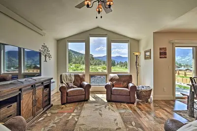 a living room with two chairs and windows at Estes Park Mountain-View Retreat 3 Miles to RMNP! in Estes Park