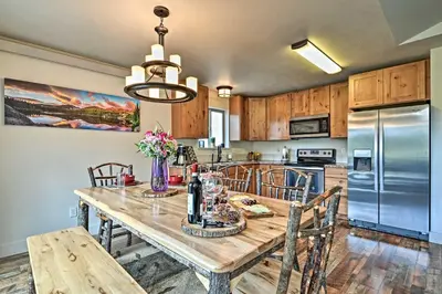 a kitchen with a wooden table with chairs and a refrigerator at Estes Park Mountain-View Retreat 3 Miles to RMNP! in Estes Park