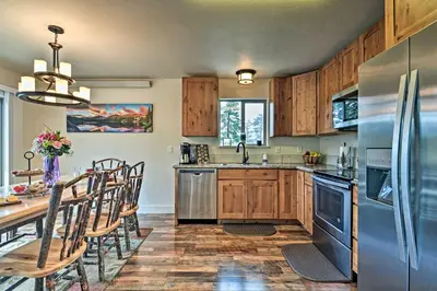a kitchen with wooden cabinets and a table with chairs at Estes Park Mountain-View Retreat 3 Miles to RMNP! in Estes Park