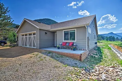 a house with two red chairs on a porch at Estes Park Mountain-View Retreat 3 Miles to RMNP! in Estes Park