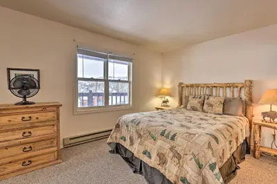 a bedroom with a bed and a dresser and a window at Fireplace and Stream Access Cozy Grand Lake Retreat in Grand Lake