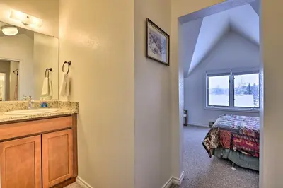 a bathroom with a sink and a mirror and a bed at Fireplace and Stream Access Cozy Grand Lake Retreat in Grand Lake