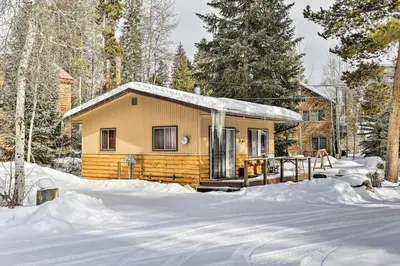 a cabin in the woods in the snow at Direct Beach Access Grand Lake Cabin with Deck! in Grand Lake