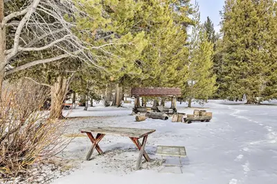 a picnic table and bench in the snow at Direct Beach Access Grand Lake Cabin with Deck! in Grand Lake