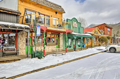 a snow covered street in a town with buildings at Direct Beach Access Grand Lake Cabin with Deck! in Grand Lake