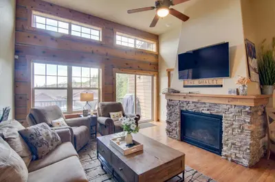 a living room with a fireplace and a flat screen tv at Winter Park Chalet with Hot Tub and Free Shuttle! in Fraser
